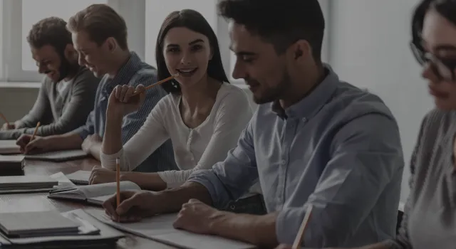 Grupo de estudiantes trabajando y conversando en clase.